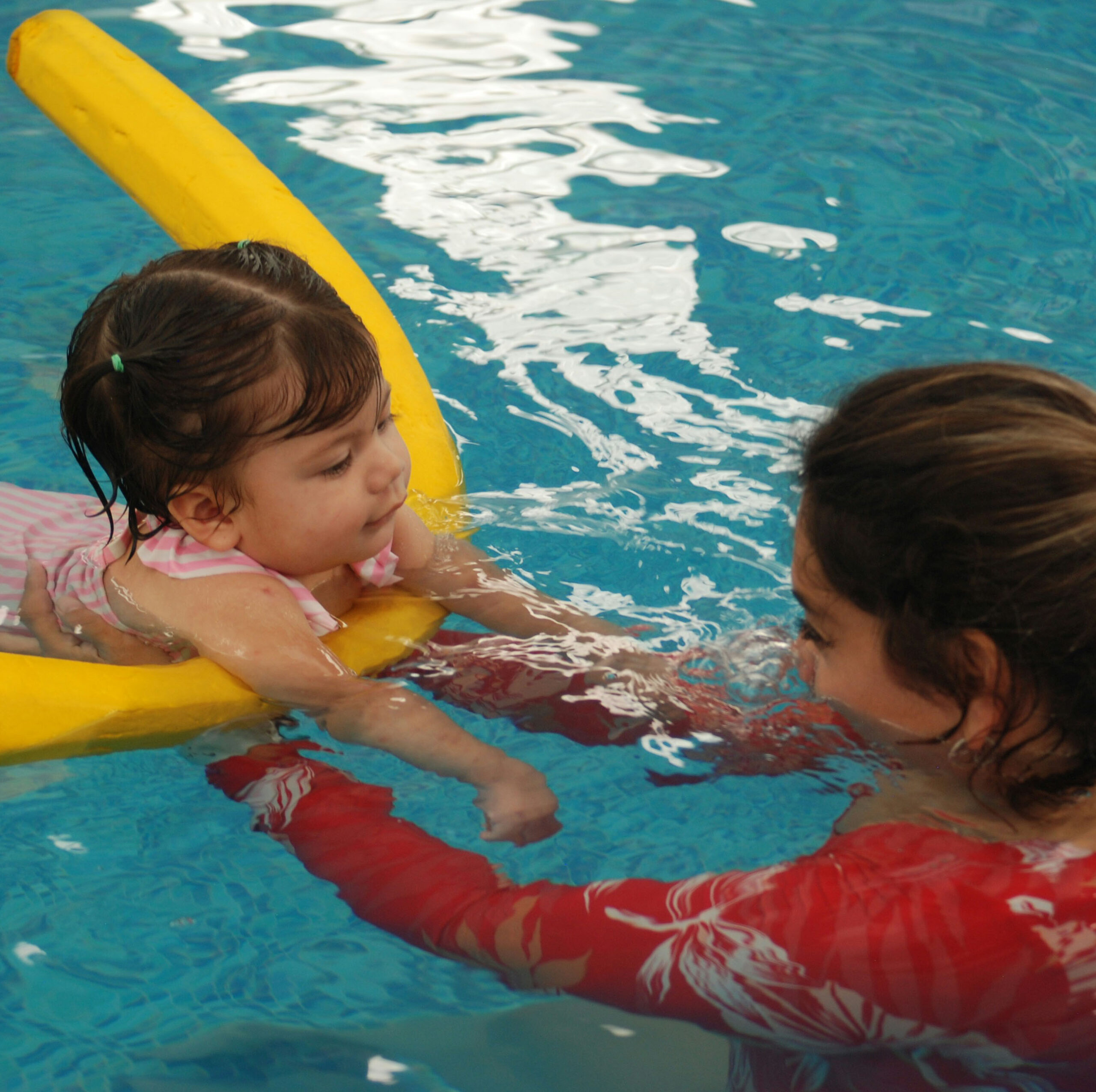 Ein Kind und eine Mutter im Schwimmbecken